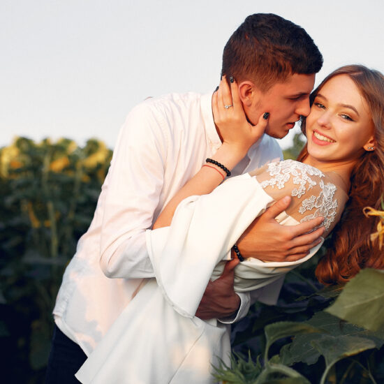 Beautiful and stylish couple in a field wirh sunflowers